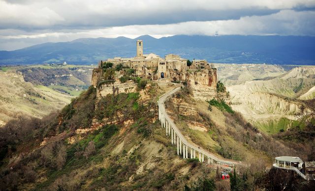 Civita di Bagnoregio sulla rupe di tufo isolata dall'erosione, collegata al paese dal ponte pedonale (2014).